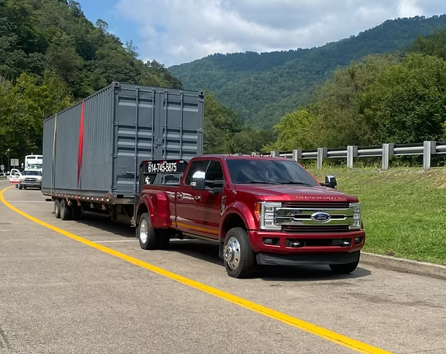 Red transport truck hauling a gray shipping container
